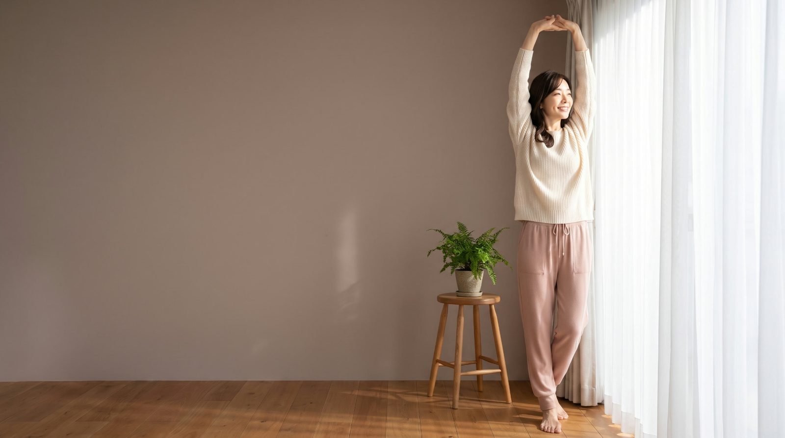 朝の光の中で、ゆっくりと伸びをしている50代の女性